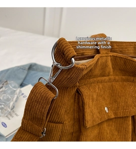 Detailed close-up of dark brown corduroy texture with premium silver D-ring hardware