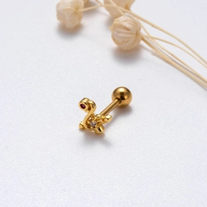 Macro shot of gold stainless steel tragus earring with red zircon in S-shape design