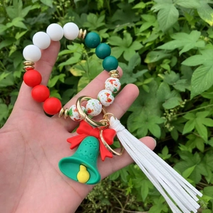 Close-up of Christmas silicone beaded bracelet with Santa charm, bell, and white tassel