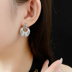 Gros plan d'une boucle d'oreille argentée en forme d'éventail avec pierres de zircon