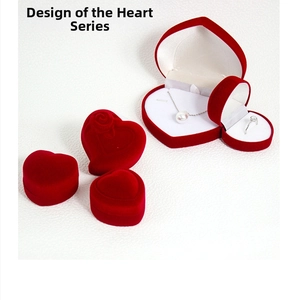 Macro detail of red velvet heart-shaped jewelry boxes with rose relief and pearl necklace
