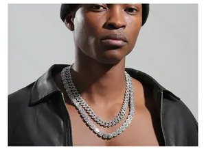 Close-up of stacked silver iced out Cuban link and square zircon tennis chain necklaces