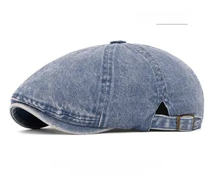 Detail of light blue washed denim beret with metal adjustment buckle and retro texture