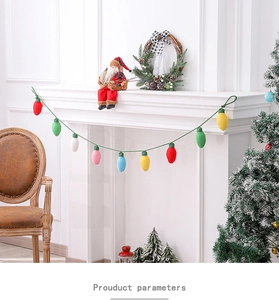 Colorful fabric Christmas light bulb garlands hanging on a white fireplace mantle