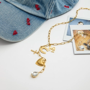 Détail du collier doré multi-pendentifs avec croix en strass et cristal en forme de poire