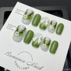 Handmade press-on nail set featuring 3D floral designs and bows on forest green gradient