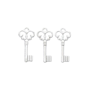 Detailed view of three silver vintage crown key charms with intricate metal patterns