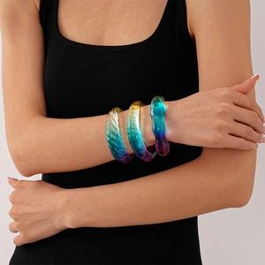 Detail of colorful gradient resin bangles with ripple texture on a model's wrist