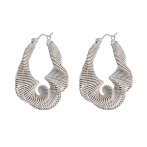 Detailed macro view of silver spiral earrings with intricate twisted metal wire texture