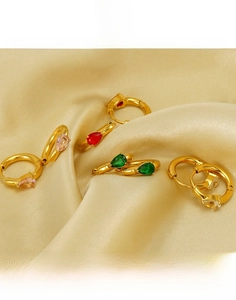 Vue détaillée des boucles d'oreilles goutte en acier titane doré avec zircons colorés