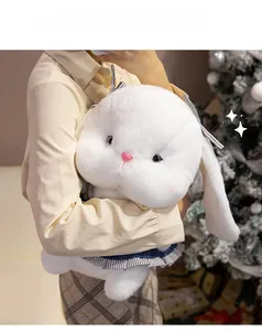 Close-up of a large white plush bunny wearing a blue dress held against a festive backdrop