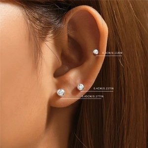 Close-up of model wearing three sizes of s925 silver stud earrings with diamond accents