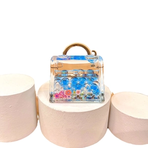 Luminous glowing bag pendant with blue bubble beads and liquid sand on white display stand