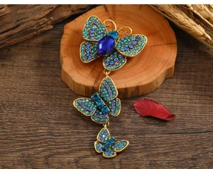 Detailed view of vintage butterfly brooch with blue rhinestones and turquoise accents
