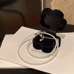 Detail of white pearl necklace with gold-plated lobster clasp and adjustable chain extender
