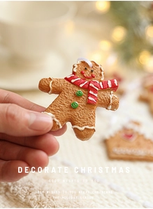 Close-up of a resin gingerbread man ornament with red scarf and festive holiday details