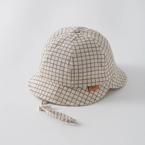 Detail view of plaid baby sun hat with adjustable drawstring and leather logo patch
