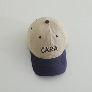 Close-up of CARA letter embroidery on kids' two-tone beige and navy baseball cap
