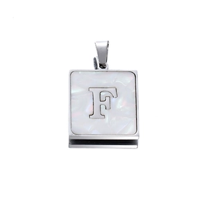 Detailed view of silver square pendant with white shell inlay and letter F engraving