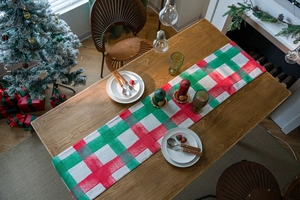 Close-up of red and green plaid Christmas table runner with festive fabric texture