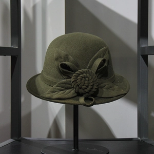 Detail of elegant dark green wool felt dome hat with side flower and leaf decoration