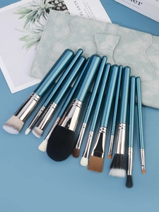 Dettaglio del set da 11 pennelli trucco con manici glitter blu e borsa con fiocco