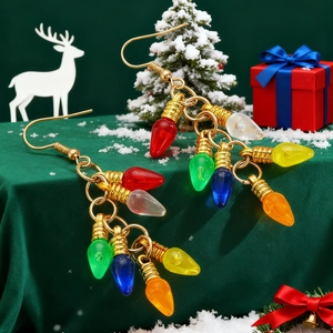 Détail macro de boucles d'oreilles ampoules de Noël colorées sur fond velours vert festif