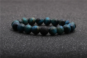 Macro shot of blue tiger eye beads and black volcanic stone with natural pore texture