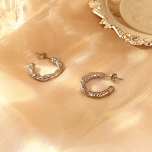 Silver vintage pleated C-shape earrings on silk satin for a minimalist jewelry look