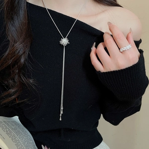Detail of silver starburst pendant necklace and full diamond wide ring on model