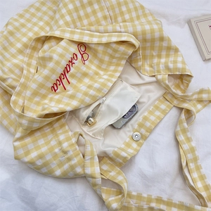 Detail of yellow checkered tote bag interior with zipper pocket and magnetic closure