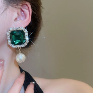 Detail view of vintage emerald square earrings with crystal halo and white pearl drops