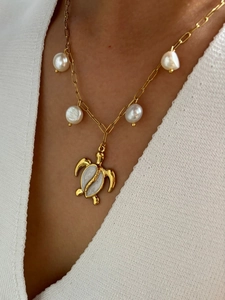 Detail of sea turtle pendant necklace with baroque pearls on gold rectangle link chain