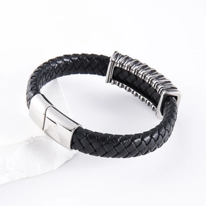 Braided black leather bracelet with stainless steel clasp on a white textured stone