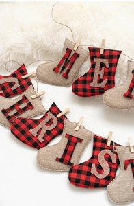 Détail d'une banderole de Noël en toile de jute et carreaux rouges sur peluche blanche