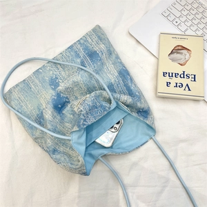 Detail view of tie-dye tote bag showing inner capacity with a smartphone inside