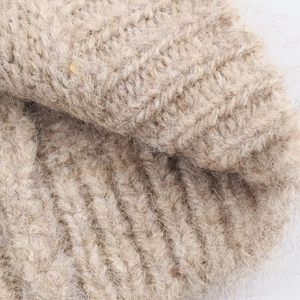 Vista dettagliata del tessuto a maglia beige del cardigan in lana e mohair