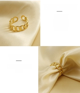 Detailed macro view of gold-plated stainless steel chain link ring on silk background