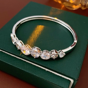 Detailed close-up of a silver-toned bangle featuring six graduated round zircon stones