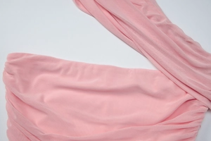 Detailed close-up of pink elastic mesh fabric texture with delicate pleats and wrinkles