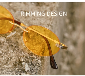 Close-up of frameless vintage oval sunglasses with golden trimming design detail