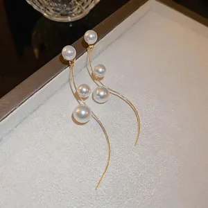 Elegant long wave gold pearl earrings with tassel design and silver needle for women