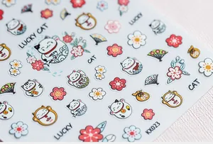 Macro shot of 5D nail stickers featuring Maneki-neko cats, cherry blossoms and fans