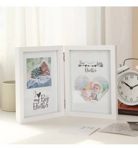 Detail of white 5x7 inch foldable wooden picture frame with hinges on light desk