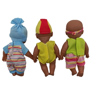 Rear view of three realistic black baby dolls in colorful outfits on white background