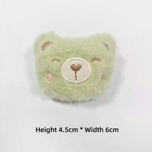 Detail of light green plush bear head patch with embroidered heart, 4.5cm by 6cm