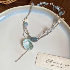 Detail view of multi-layer ocean necklace with starfish charms and shell pendant