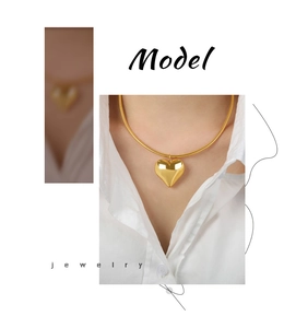Detail of 18k gold plated hollow heart pendant with thick snake chain on a model