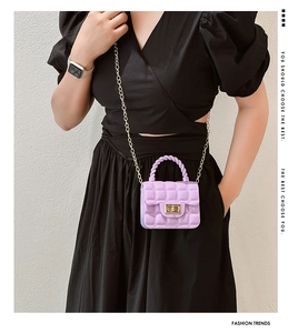 Detail of purple quilted jelly bag with gold chain strap worn cross-body by a model