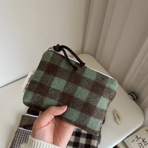 Macro view of plaid wool fabric texture and white zipper on mini organizer pouch